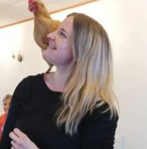 Nathalie Stalon, souriante, une poule perchée sur son épaule